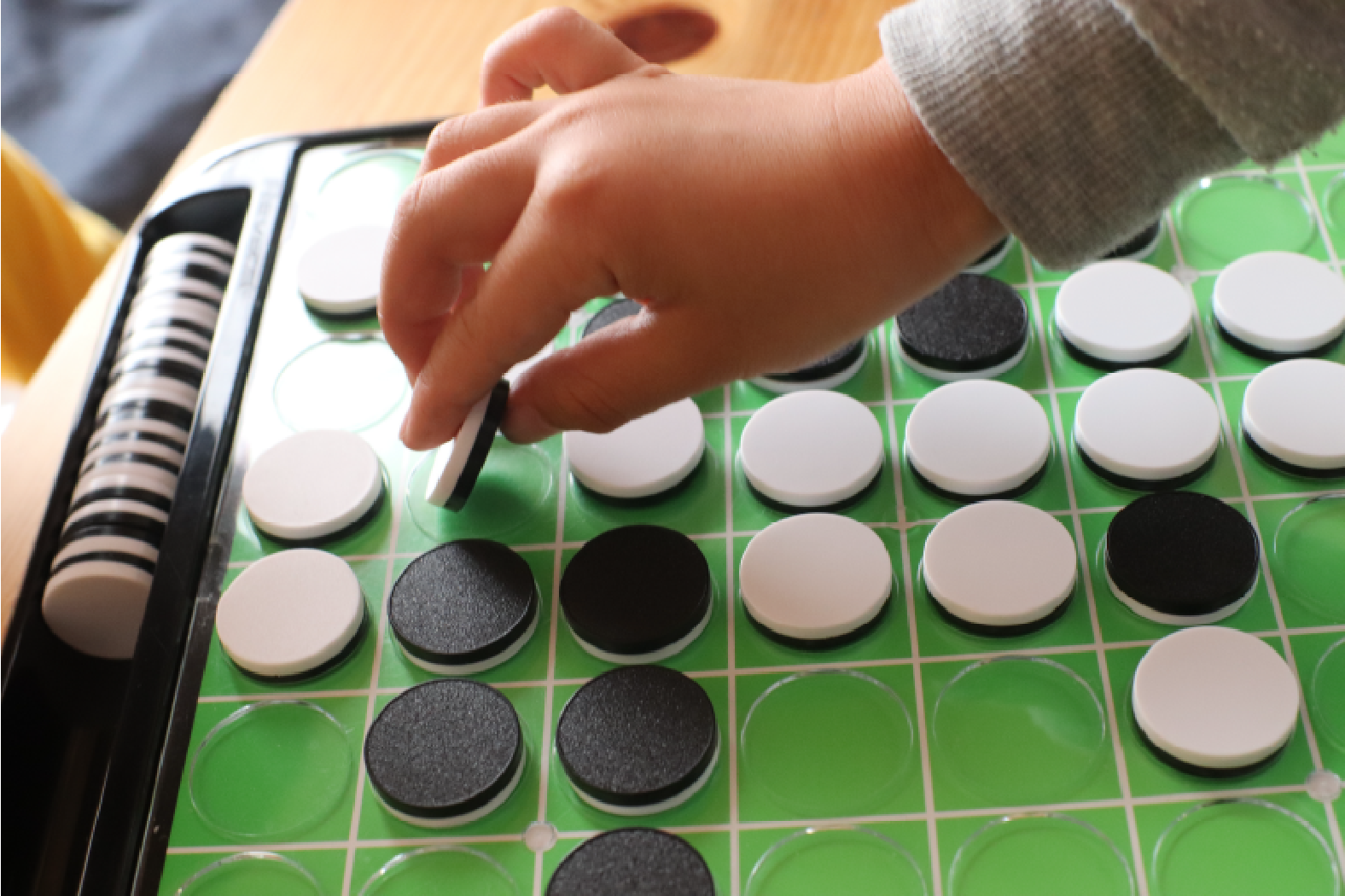 Playing the game Reversi or Othello.